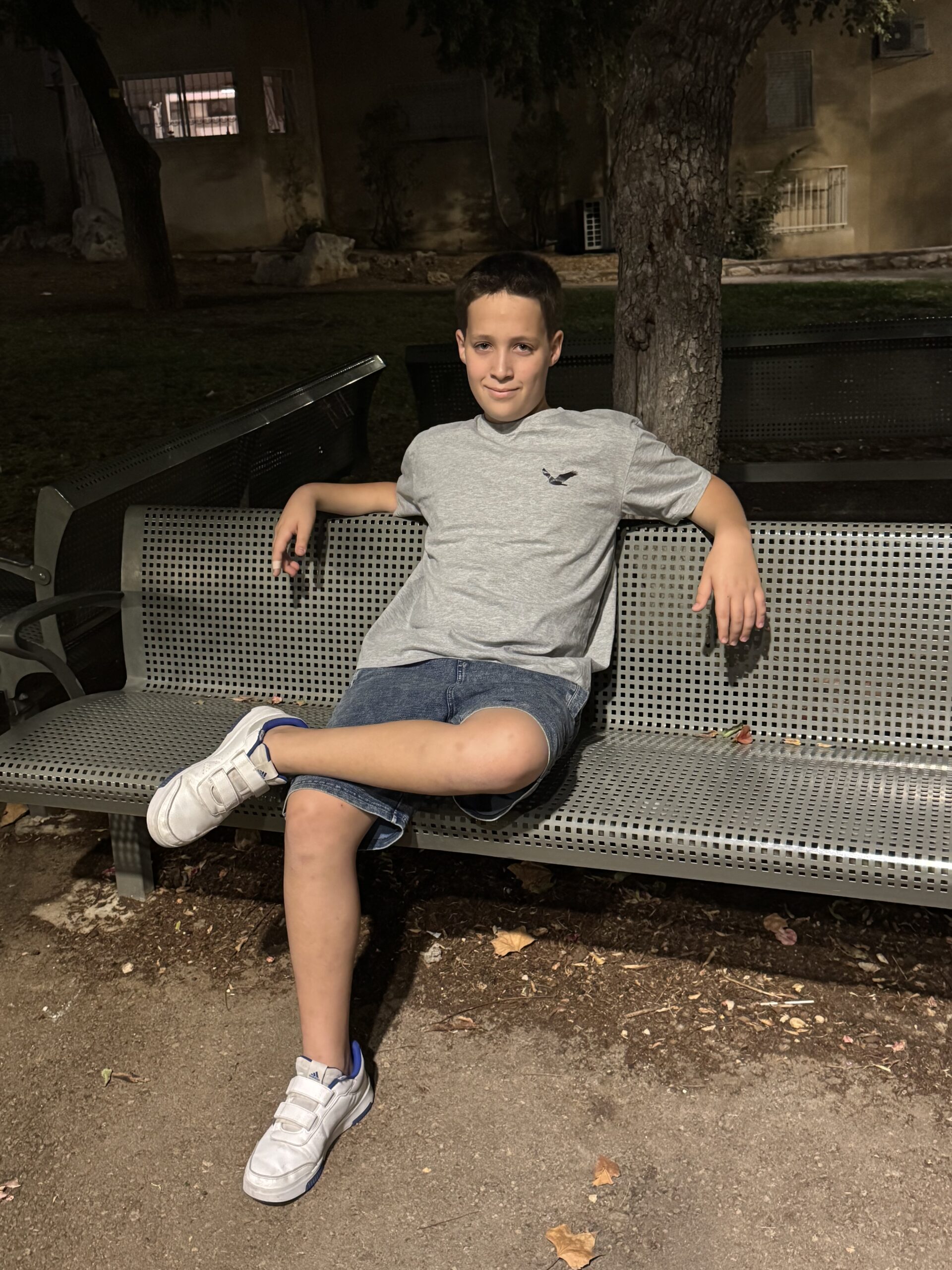 נער יושב על ספסל בתל אביב